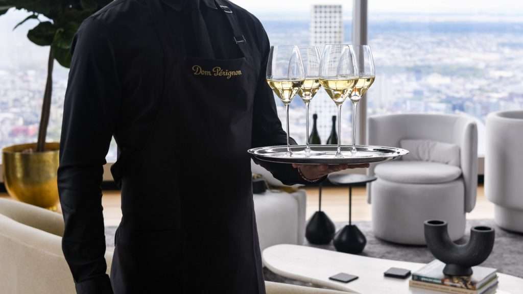 Dom Perignon waiter carrying tray of champagne.