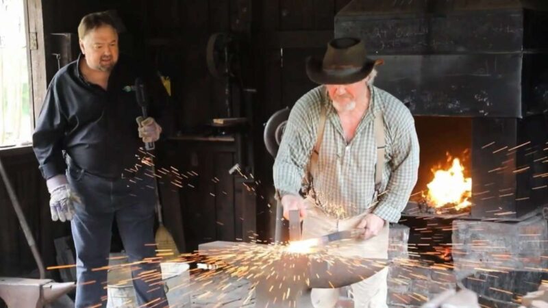 Blacksmith hammering hot iron rod