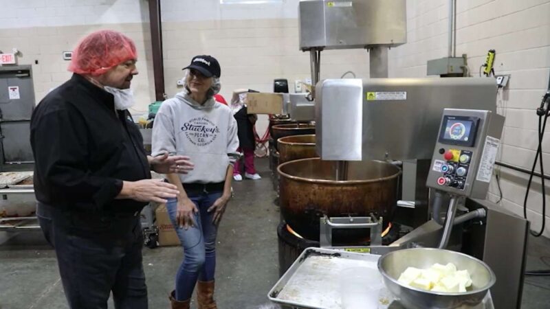 Chip and Stephanie Stucky standing in front of a copper kettle.