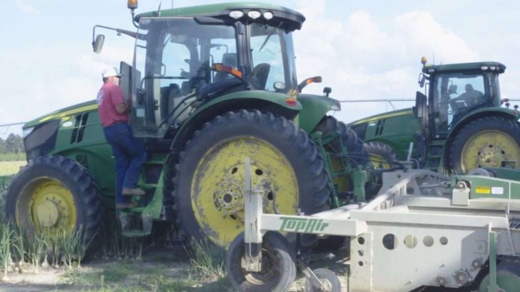 Farmer climbing into tractor