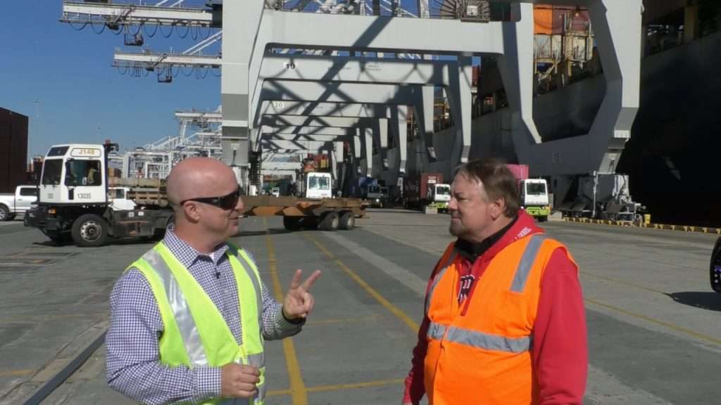 Chip at Port of Savannah with cargo ship in background.