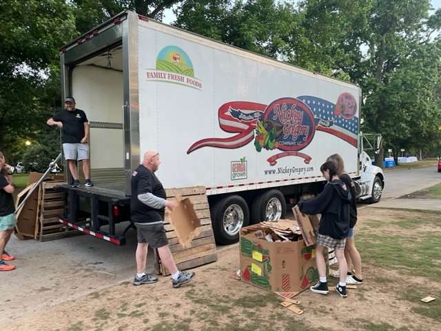 Volunteers unload Nickey Gregory produce truck. 