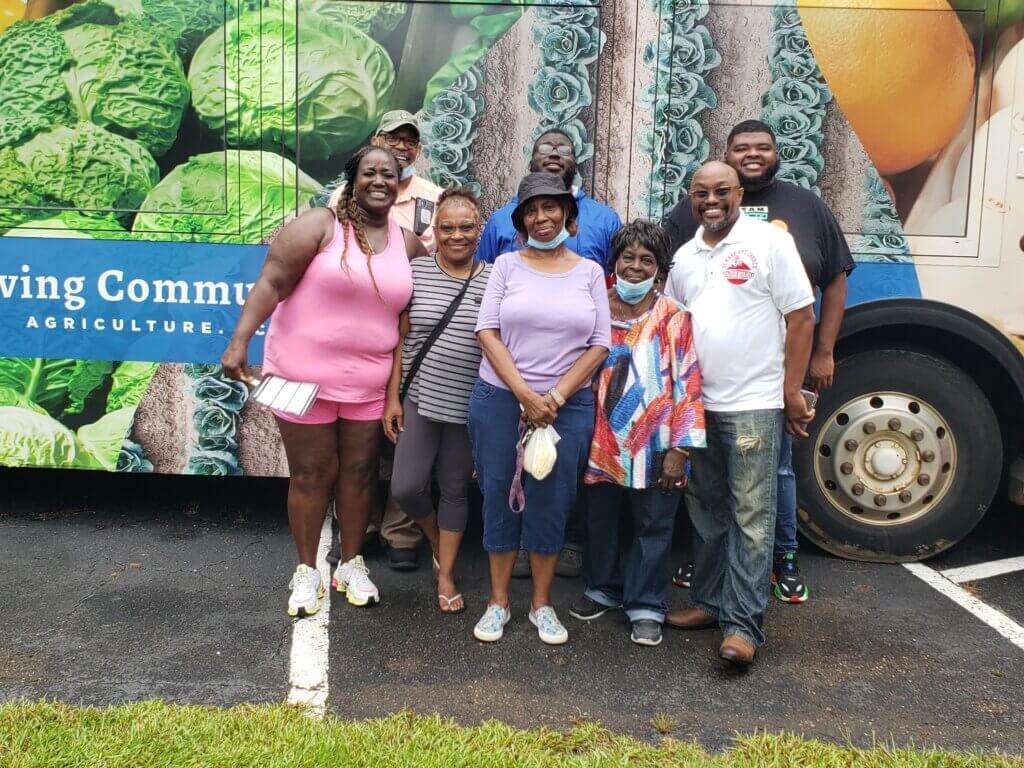 Shoppers from the Community in front of Ripe Revival mobile market bus. 