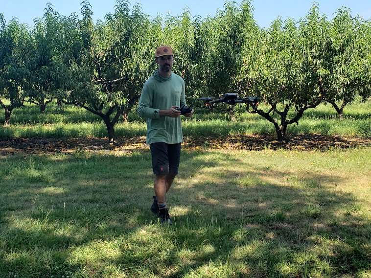 Crew member flying camera drone. 