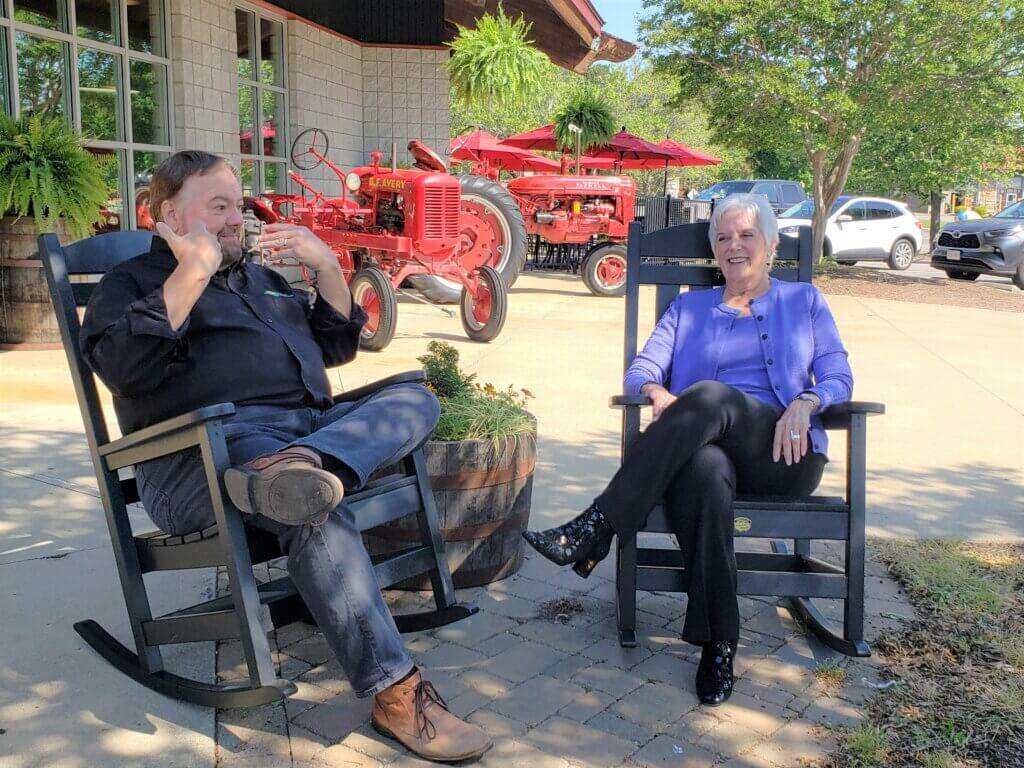 Chip and Gypsy Gilliam chatting outside the restaurant in rocking chairs. 