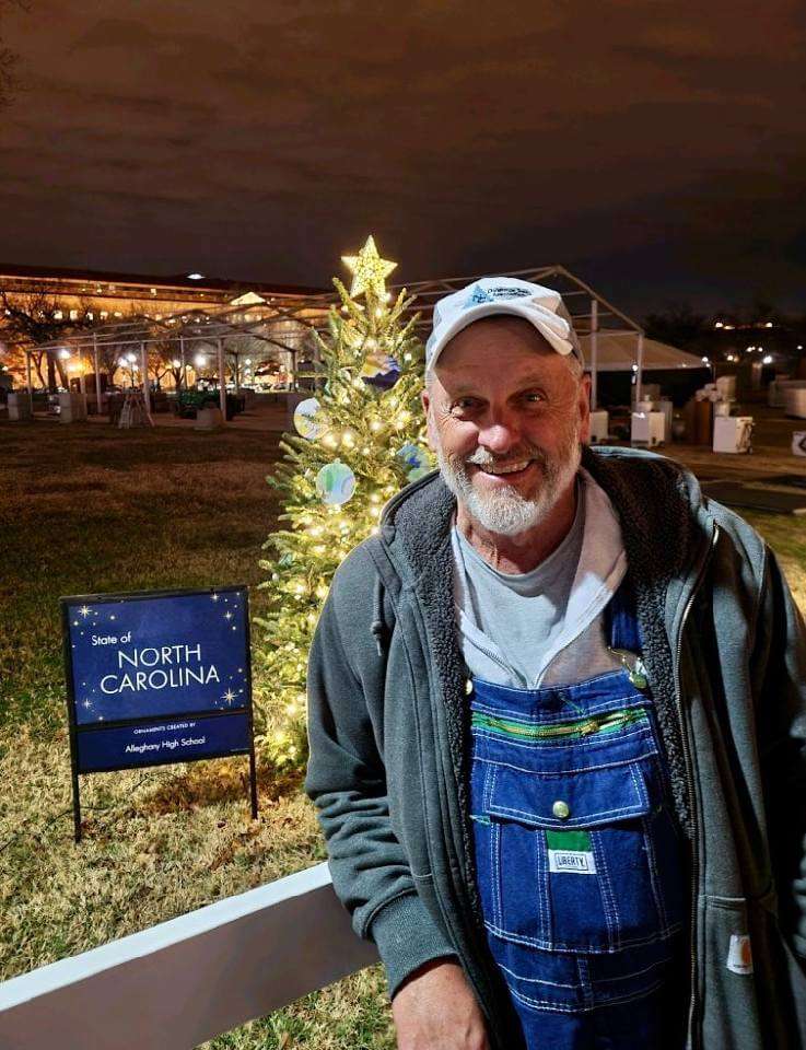 Larry Smith in front of Christmas tree