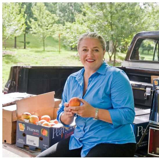 Virginia Willis holding fresh picked southern peaches. 