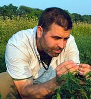 Dr. Zach Lippman holding a plant. 