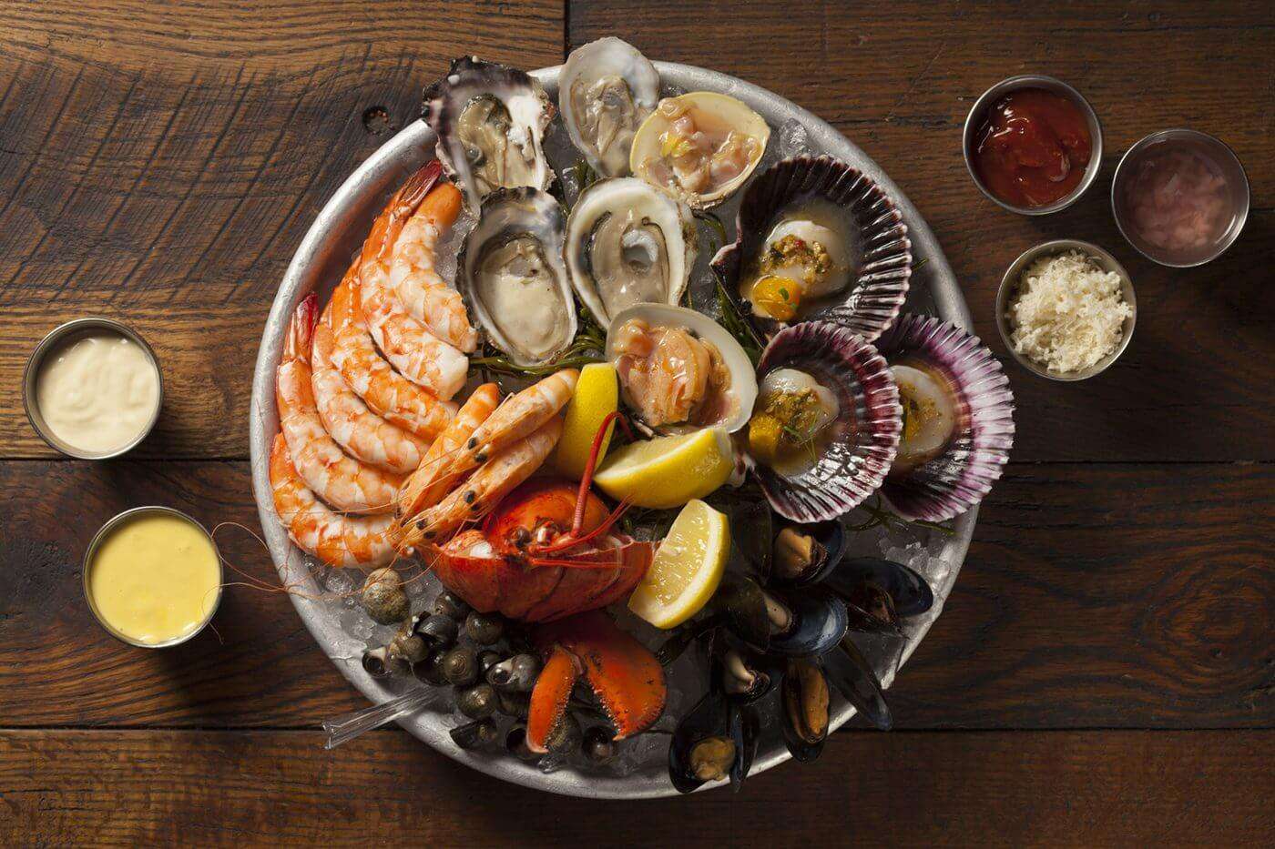 Plate of assorted shellfish and sauces on the side. 