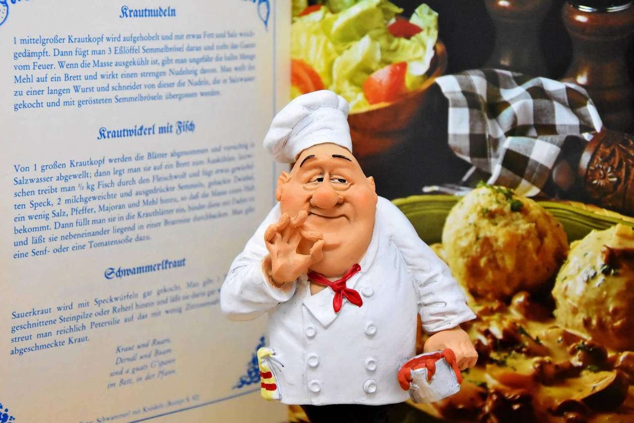 Character chef in front of cookbook.