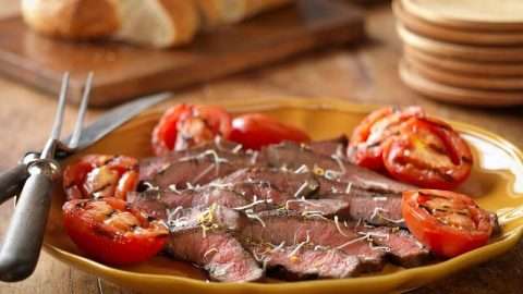 Grilled balsamic steak and tomatoes on a plate.