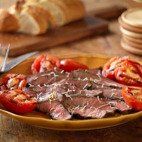 Grilled balsamic steak and tomatoes on a plate.