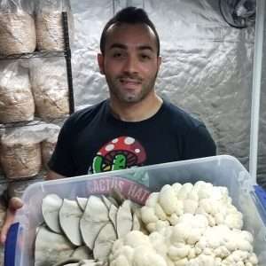 Joe holding large container of assorted mushrooms.