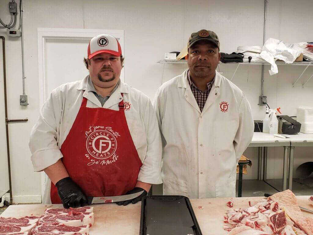 Butchers slicing steaks. 