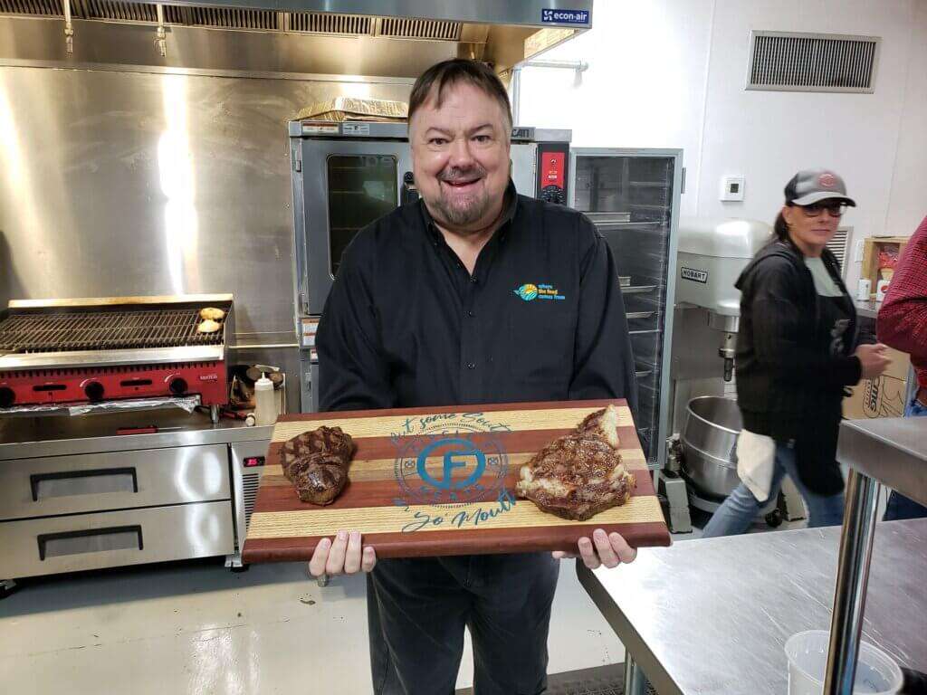 Chip holding steaks fresh off the grill.