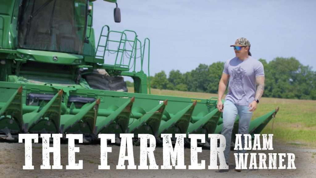 Adam Warner standing in front of tractor in music release poster.