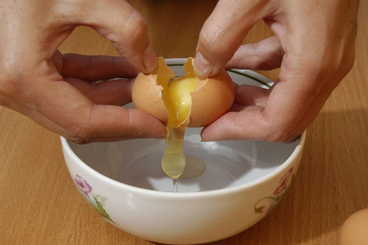 Cracking egg in bowl.