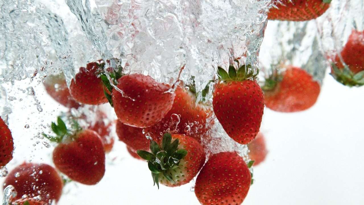 Strawberries being splashed with water.