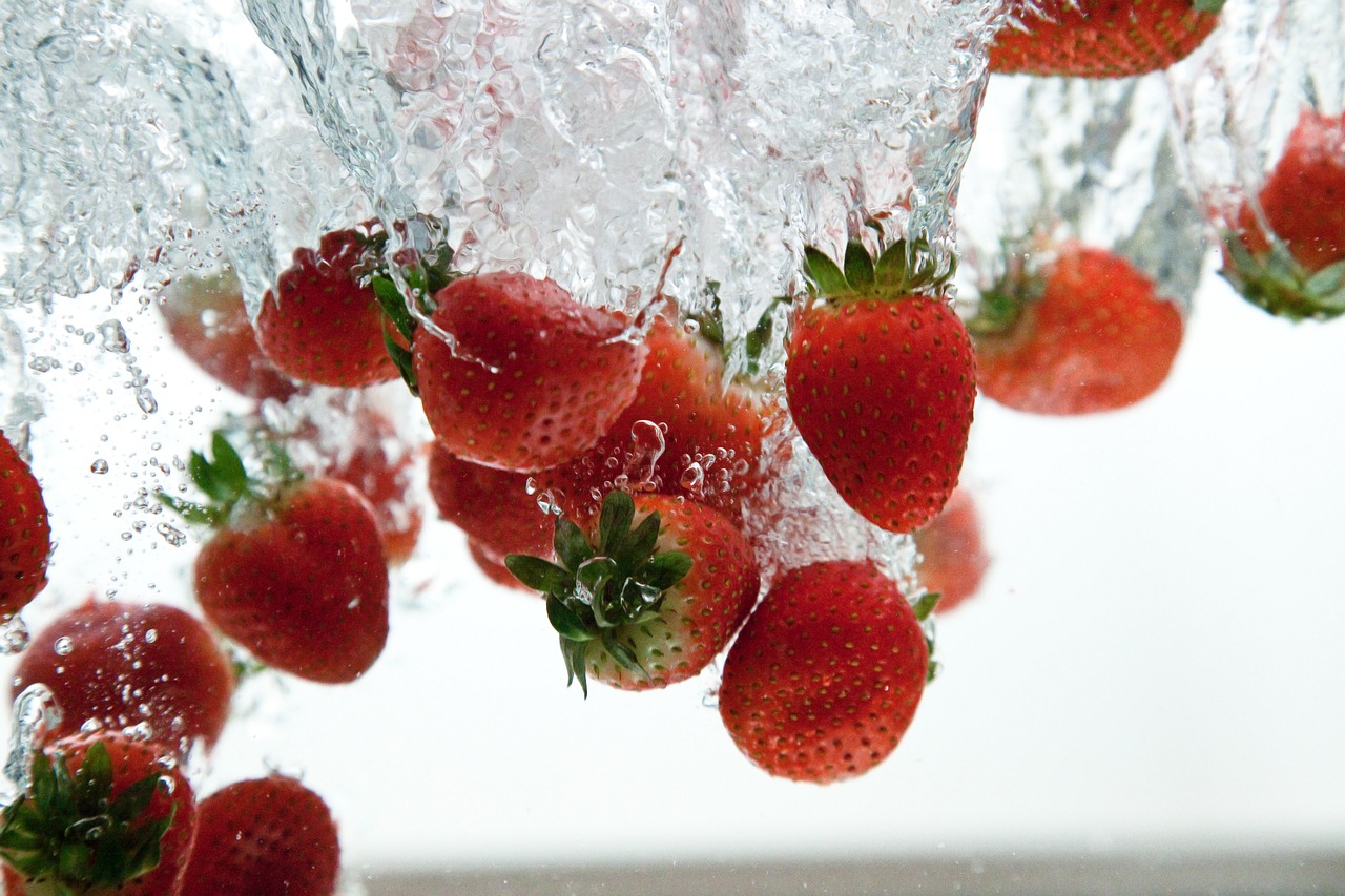 Strawberries being splashed with water.