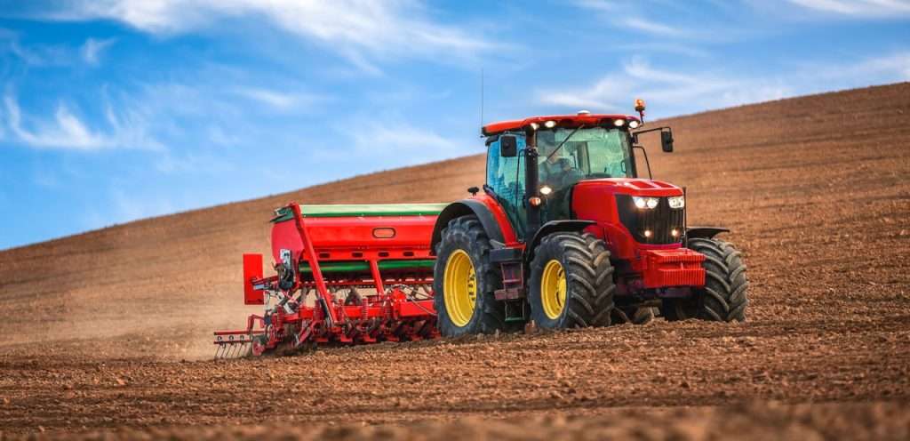 Tractor towing a harvestor.