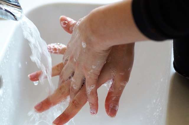 Washing hands and in between fingers with running water.