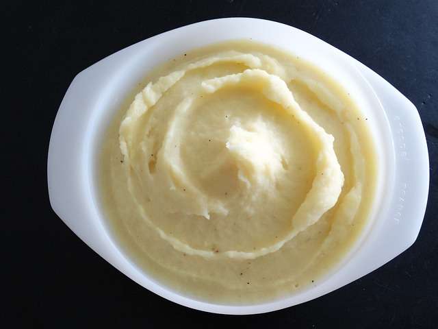 Mashed potatoes in a white oval bowl.