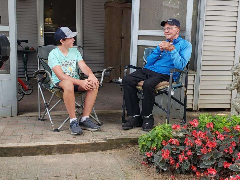 Weston Hannan and Bob Heath talking on front porch.