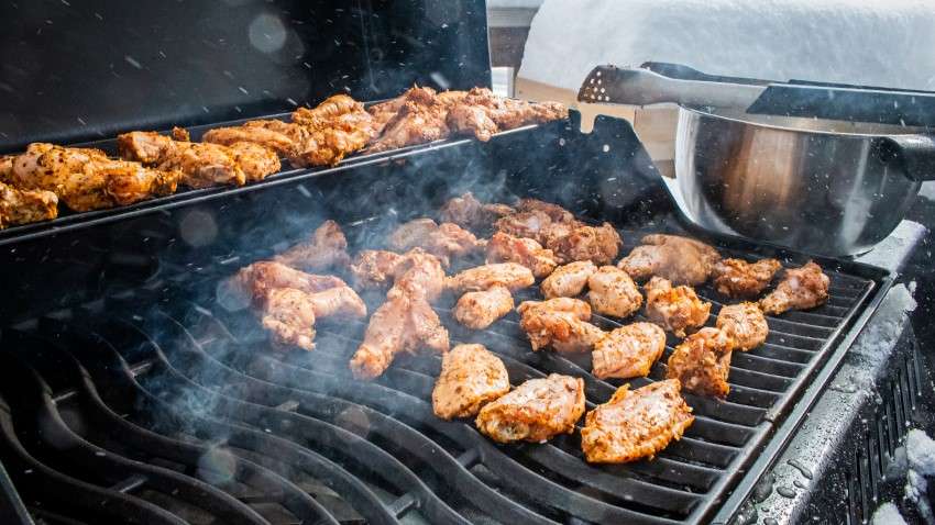 Chicken wings cooking on grill. 