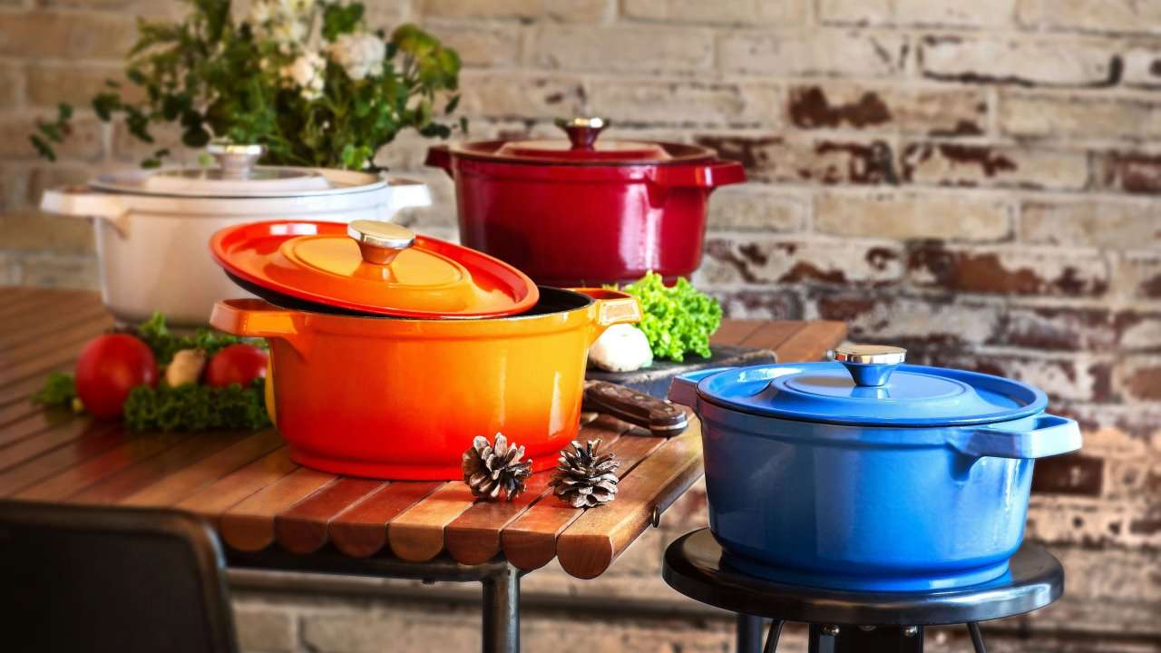 Three Dutch Ovens different colors on a counter in the kitchen.