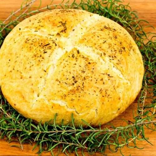 Round white bread with ring of Rosemary around it.