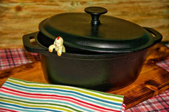 Black cast iron roaster with little man coming out on a cutting board. 