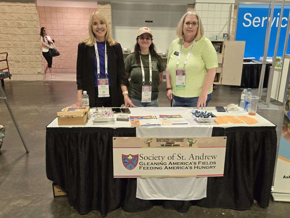 Kelly Stainner, Rebecca Brockman and Lynette Johnson, Society of St. Andrew at display table convention center.