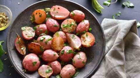 Close up of roasted radish on plate over blue stone background.