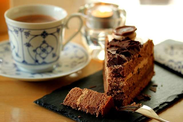 Chocolate layer cake with cup of coffee.