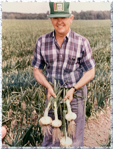 Buck Shuman holding harvested Vidalfia Onions in the field. 