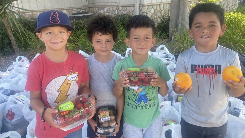 Kids holding fresh produce.