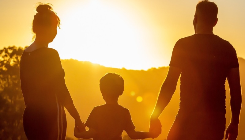 Family holding hands at sunset. 