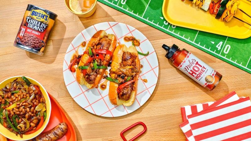 Tailgate spread featuring hot dogs with the new Bush's and Mike's Hot Honey Grillin Beans. 