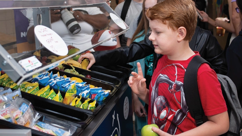 Student selecting snacks from school cafeteria.