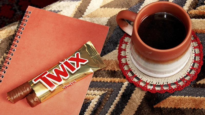 Open Twix next to a cup of coffee. 