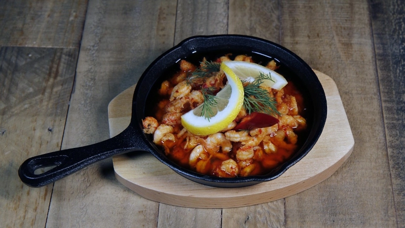 Shrimp, lemon and rosemary sizzling in a cast iron skillet. 