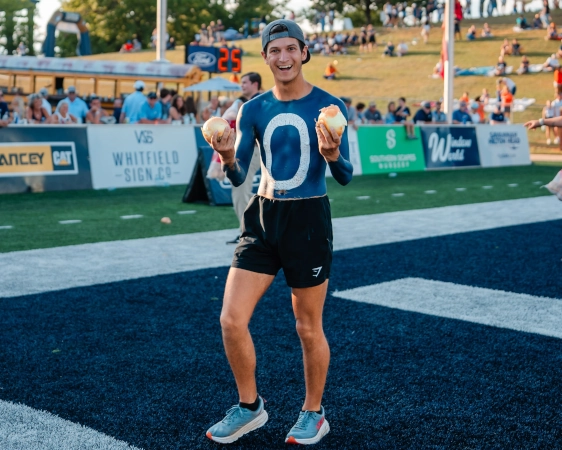 Young man holds an onions in the endzone. 