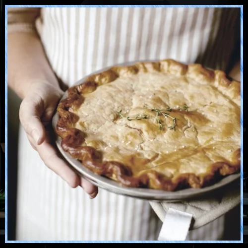 Lady holding a fresh chicken pot pie.