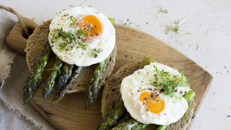 Sunny side up egg over asparagus and whole grain toast. 