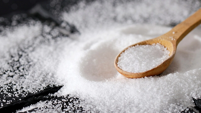 Grains of salt in a wooden spoon.