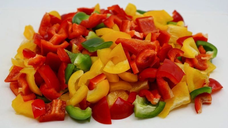 Diced green, yellow and red bell peppers.