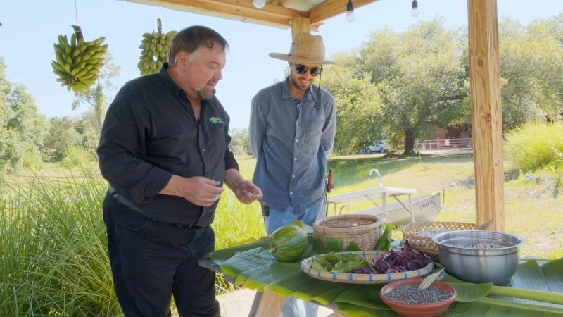 Chip discussing a table of assorted beans and tropical fruits.