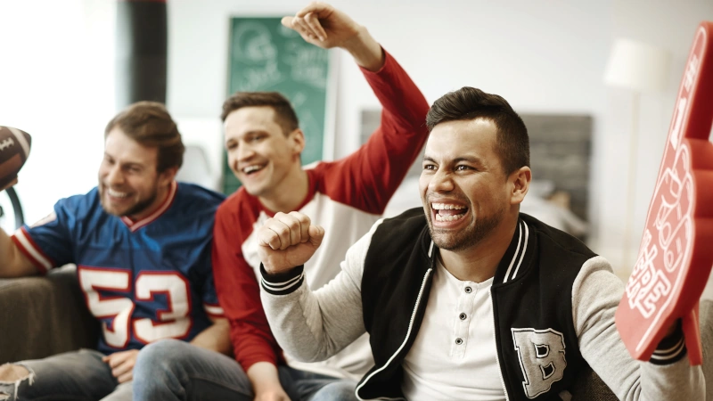 Fans in livingroom watching football.