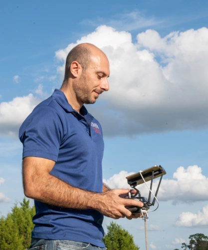 Man controlling a drone in a field.