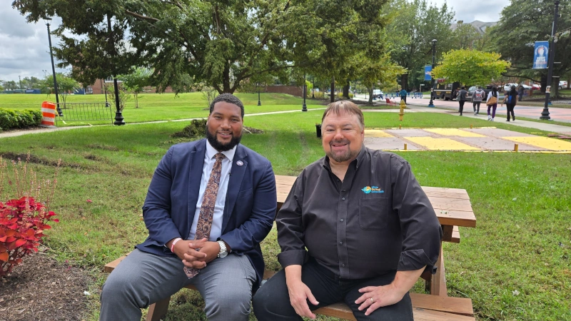 Eldon Burton and Chip Carter sitting at a picnic table on the campus of VSU.
